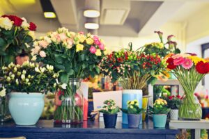 A colorful array of flowers in various vases inside a modern florist shop.